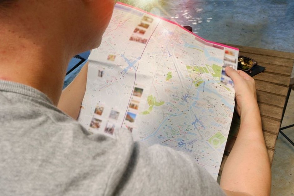A person studies a city map during an everyday walking trip.